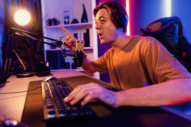 Kazanmak için çevrimiçi oyun oynayan akıllı flama makinesinin sunucu kanalı, neon ışıklı odada seçilen takım yarışması için izleyicilerle birlikte canlı yayında canlı yayında kulaklık takıyor. Bireysel.