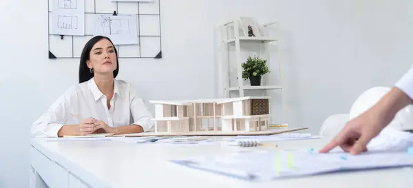 stock image Closeup image of professional cooperative engineer team discuss about building location at modern office. Male engineer put the map on table while beautiful architect taking a note. Immaculate.