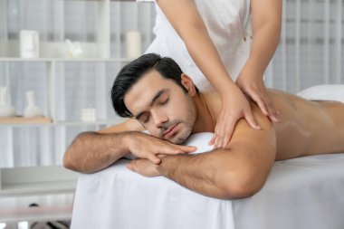 Kafkas erkek müşteri stres önleyici spa masajının keyfini çıkarıyor ve lüks otel veya oteldeki gündüz açık hava ortamında güzellik derisi eğlencesi ile şımartıyor. Sessiz.