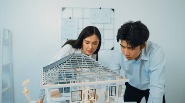 Modern ofisteki ev modeli yapısını kontrol etmeye odaklanan genç, profesyonel mimar mühendis ekibine yakın çekim. Yaratıcı profesyonel tasarım ve takım çalışması konsepti. Tertemiz..