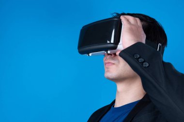 İlginç iş verilerine metaevreni bağlamak isteyen VR kulaklık takan profil işadamının heyecan verici profili, meta finansta sanal gerçeklikte mavi arka plan fütüristik teknolojisini izole etti. Entrika.