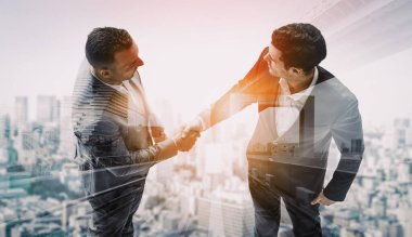 İş adamlarının arka plandaki belediye binasında el sıkışması ortaklık anlaşmasının başarısını gösteriyor. Kurumsal takım çalışması, güven ortağı ve iş anlaşması kavramı. uds