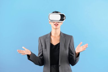 Kafkasyalı yetenekli iş kadını VR gözlük takarken açıklıyor. Mavi arka planda dururken görsel gerçeklik yeniliklerini kullanan yetenekli bir proje yöneticisi. Fütürist teknoloji. Kısıtlanma.