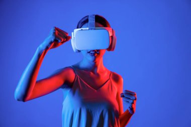 VR kulaklık takan zeki bir kadın metaevrene bağlanıyor, gelecekteki siber uzay topluluğu teknolojisi. Duruş kontrol oyuncusunu yumruklayan zarif bir kadın dövüş oyunları oynuyor. Halüsinasyon.