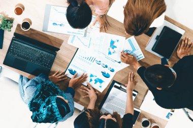 Modern ofisteki iş adamları ve iş kadınlarıyla grup toplantısındaki iş adamlarının en üst düzey görüşü, masada dizüstü bilgisayar, kahve ve belge ile. Kurumsal şirketler uds