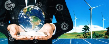 Alternatif enerji ile sürdürülebilirlik gelişimi kavramı. Çevre dostu rüzgar türbini çiftliği ve arka planda yeşil yenilenebilir enerji olan gezegenle insan eli ilgilenir. uds