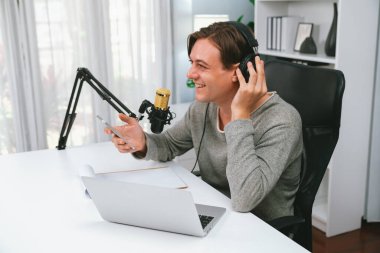 Sunucu kanalı, gülümseyen akıllı yayıncı kaydı, senaryosu ve akıllı telefonuyla sosyal medyada sohbet programı, kulaklık takarak modern ev stüdyosundaki video flamalarını kaydediyor. Bireysel.