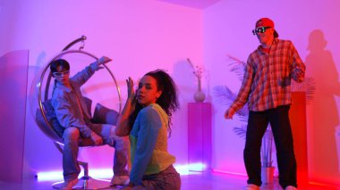 Çekici mutlu dansçı kameraya bakarken zeki kadın neon ışıkla kafiyeli hareket ediyor. Profesyonel İspanyol şarkıcı çeşitli arkadaşlarıyla renkli kıyafetler giyerken break dans yapıyor. Mutluluk.