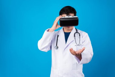 VR kulaklık takan zeki doktor analitik tıp araştırmaları içeren verileri birleştirmeye çalışıyor. Mavi arka plan fütüristik teknoloji hologramı sanal gerçeklik meta dünyası. Entrika.