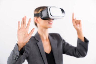 Proje yöneticisi VR gözlük kullanırken sisteme dokunuyor ve yönetiyor. Kafkasyalı iş kadını ayakta durup görsel gerçeklik kulaklığı kullanırken strateji arıyor ve planlıyor. Teknoloji. Kısıtlanma.