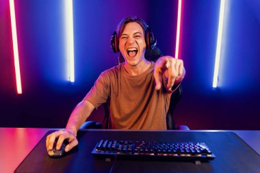 Kazanmak için çevrimiçi oyun oynayan akıllı flama makinesinin sunucu kanalı, neon ışıklı odada seçilen takım yarışması için izleyicilerle birlikte canlı yayında canlı yayında kulaklık takıyor. Bireysel.