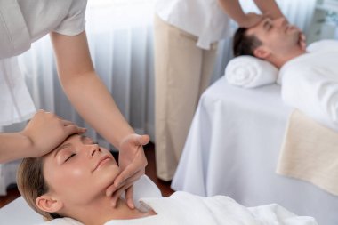 Kafkasyalı çift stres önleyici kafa masajının keyfini çıkarıyor ve lüks otellerde ya da otel spa salonlarında gündüz kaplıcalarında yüz güzelliği eğlencelerini şımartıyor. Sessiz.