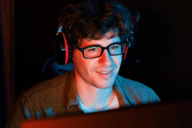 Genç oyun flaması takımı, Esport ile birlikte neon ışıklı odada kulaklık takarak online dövüş kazanan oyuncuları topluyor. Bir sonraki seviyeye rakip kazanmak için strateji planı uyguluyorum. Toplayıcı.