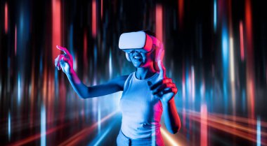 Meta-meta 'da siber punk stilinde ayakta duran zeki kadın metaevrene bağlı VR kulaklık takıyor, gelecekteki siber uzay teknolojisi kullanıyor, kadın sanal gerçekliğe dokunan bir nesne kullanıyor. Halüsinasyon.