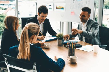 İş adamı yönetici, diğer iş adamları ve iş kadınlarıyla modern ofiste kahve fincanları ve belgelerle grup toplantısı yapıyor. Şirket çalışanlarının ortak çalışma konsepti. uds