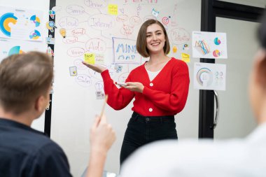 Erkek proje yöneticisinin yakın plan görüntüsü soru sormak için el kaldırırken, genç güzel lider zihin haritası ve renkli yapışkan notlar kullanarak iş projesini kendinden emin bir şekilde sunuyor. Tertemiz..