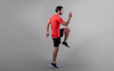 Vücut uzunluğunun tamamı atletik ve sportif genç erkek fitness 'in izole edilmiş arka planda kardiyo egzersizi duruşunu gösteriyor. Sağlıklı aktif ve vücut bakımı yaşam tarzı.
