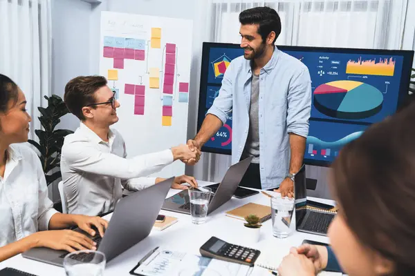 Analist ekip lideri, iş zekası ya da BI gösterge paneli ile FIntech yazılım gücünü kullanarak başarılı veri analizi toplantısından sonra iş arkadaşıyla tokalaştı. Tedbirli