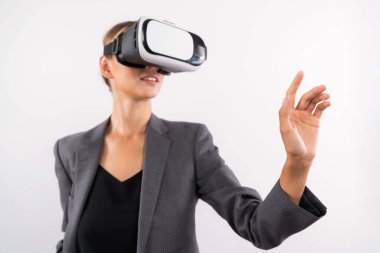 Profesyonel kadın lider programa dokunuyor ya da sanal gerçeklik gözlüğü kullanırken çalışıyor. Yetenekli iş kadını, görsel gerçeklik gözlüğü takarak metaevrene bağlanırken sistemi işaret ediyor. Kısıtlanma.