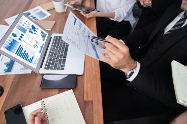 Ofis masasındaki finansal veri raporlarını analiz eden çeşitli bir grup iş analisti. Stratejik pazarlama planlaması için iş istihbarat analizine göre grafikler ve grafikler.