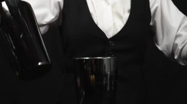 Makrografi, dikkat çekici bir siyah arka planda ustalıkla kokteyl karıştıran bir barmenin becerikli ellerine tanık olun. Her yakın çekim sıvı hareketini ve dinamik enerjiyi yakalar. Geliştirilebilir.