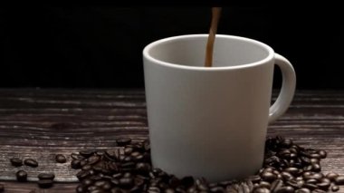 Kahve makinesi fincana siyah arka planda aromatik sıcak kahve dolduruyor. Sıcak kahve ya da espresso beyaz kahve bardağına dökülüyor ve kaynamış suya dökülüyor. Geliştirilebilir.
