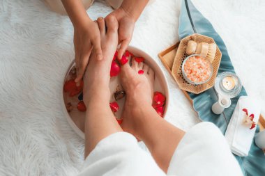 Kadınlar lüks spa salonlarında keyifli ayak masajlarına devam ederken, masör de hafif gün ışığı atmosferinde refleksoloji terapisi veya otel ayak spa 'sında. Sessiz.