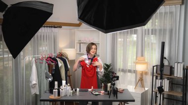 Kadın nüfuzlu kişi video görüntülerini canlı yayınlıyor. Kıyafetler sosyal medyada ya da blogda yer alıyor. Stüdyo ışıklandırmalı mutlu genç kız çevrimiçi pazarlama oturumu yayını için..