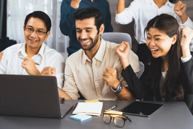 Heyecanlı ve mutlu bir ofis çalışanı başarılı bir stratejik iş pazarlama planlaması yaptıktan sonra kutlama yapıyor. Takım çalışması ve olumlu tutum verimli ve destekleyici bir iş yeri yaratır. Tedbirli