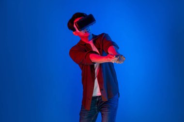 VR gözlük takan akıllı bir oyuncu golf kursu hologramı, metaevren dünyasındaki dijital fütüristik teknolojiyi birbirine bağlayan açık mavi ekranı izole etti. Entrika.