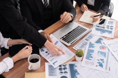 Ofis masasındaki finansal veri raporlarını analiz eden çeşitli bir grup iş analisti. Stratejik pazarlama planlaması için iş zekası analizi çizelgesi ve grafiği.