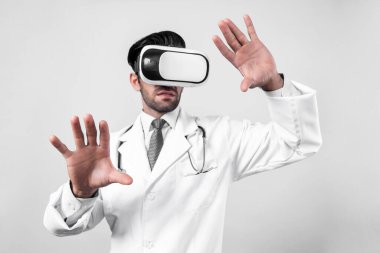 Tıbbi form tutarken VR gözlük ve laboratuvar önlüğü takan profesyonel bir doktor. Metastaz ya da sanal gerçeklik dünyasını hastalarla konuşmak ve onları iyileştirmek için kullanırken şekle bakan çekici bir doktor. Sapma.