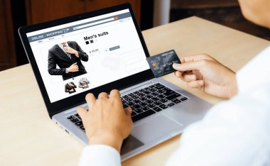 Genç adam, laptop bilgisayar başvurusu ya da web sitesinde online alışveriş yapmak için kredi kartı kullanıyor. E-ticaret ve online alışveriş konsepti. uds