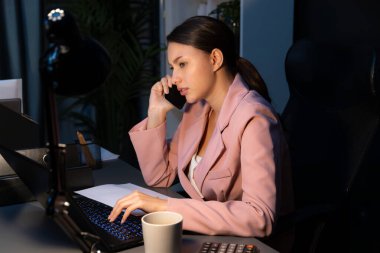 İş kadınının ciddi yüzü, gece ofisinde dizüstü bilgisayarla çalışırken yeni müşteri hedefleri için yaratıcı iş projesi planlaması için müşteriyi arıyor. Varsayım.