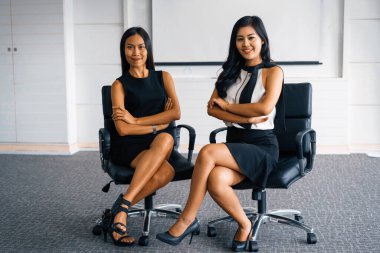 Ofiste oturan iki genç Asyalı iş kadını. İş arkadaşları ve toplum konsepti. uds