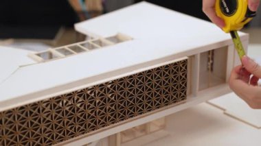 Mimari ekipman incelemesi kullanarak yavaş çekim ev tasarımcısı ve müşteri veya müşteriyle birlikte mimari ev modeli tasarım örneklerini ölçer. Filizlenen