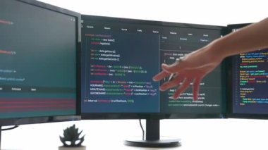 Yavaş çekim arkası yazılım geliştirici mühendisi bilgisayar programlama için birlikte çalışarak hata ayıklama kodunu çözüyor, ofiste monitörde karmaşık algoritmaları çözüyor. Filizlenen