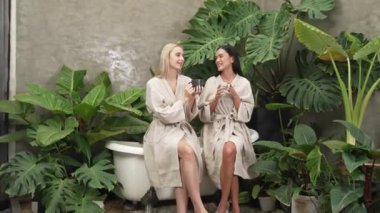 Modern otelde küveti olan tropikal ve egzotik bir spa bahçesi ya da bornozlu iki genç kadınla kahve içip, yemyeşil yeşilliklerle çevrili boş ve sağlıklı yaşam tarzının tadını çıkarmak. Blithe