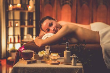 Aromaterapi masajı ambiyansı ya da spa salonu kompozisyon düzeneği bulanık kadınlara odaklı dekor mumları ve spa aksesuarları ile tatil köyü veya otel arka planında keyifli aroma spa masajı yapan. Sessiz.