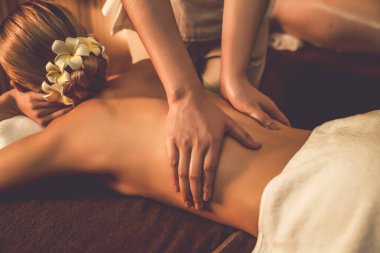 Yakındaki çift stres önleyici spa masajının keyfini çıkarıyor ve lüks otel ya da otelde sıcak mum ışığında güzellik teniyle eğleniyor. Sessiz.