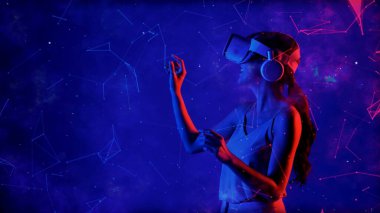 Heyecanlı gülümseyen Asyalı kadın VR metaevrenine bakıp mavi neon dijital evreni işaret ederek yıldızlı zodyak sanal uzay fantastik keşif nebulası meta-dünya. Halüsinasyon.