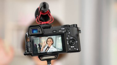 Arka görünüm, kamera ekranında kadın nüfuzunu gizler. Video görüntüleme, video görüntüleme, giysi, sosyal medya ya da blog. Canlı yayın için stüdyo ışıklandırması olan bir kız.