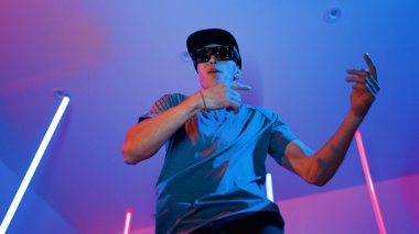 Beyaz dansçının gösterişli gözlükler taktığı ve break dans yaptığı alçak açılı kamera. Çekici adam kendinden emin bir şekilde kameraya bakarken enerjik bir performans ve hareket gösterdi. Mutluluk.