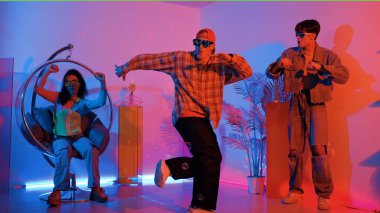 Stüdyoda gündelik kıyafetleri olan çok kültürlü bir arkadaş tezahürat yaparken mutlu hipster break dansları. Profesyonel sokak dansçısı hip hop ritmi ya da neon veya kurşun ışıkla kafiyeli bir şarkı söyler. Mutluluk.