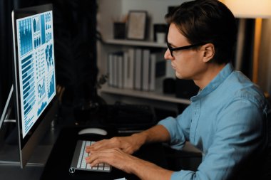 Akıllı iş adamı iş paragrafı dinamik pazarlama analizi planını analiz ediyor. Kağıt kağıtları ve bilgisayar monitörü raporlarını gece evdeki belge verileriyle karşılaştırmak için hazırlıyor. Bireysel.