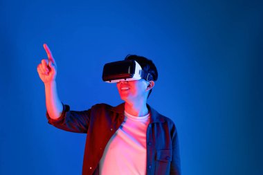 VR gözlüklerinden bakan zeki Asyalı adam, yenilikçi teknolojide dokunmatik ekran ile 3D hologram meta arayüzünü analiz ederek metazıt doğrultuda araştırma dizini verilerine dönüyor. Entrika.