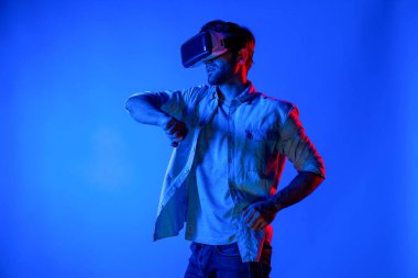 Kafkasyalı bir adam VR cam takıyor ve hareket eden el kol kılıcını tutuyor. Oyuncu, gelecekteki sanal gerçeklik kulaklığını ya da gelecekteki yenilikleri kullanarak meta dünyaya giriyor ya da aksiyon oyunu oynuyor. Sapma.