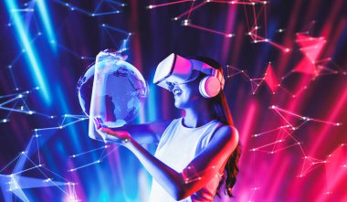 Siberpunk neon ışıklı kadın duruşu beyaz VR kulaklık takar ve metaevreleri birbirine bağlayan kolsuz tişört giyer, gelecekteki siber uzay topluluğu teknolojisi. Bir kadın 3 boyutlu küresel görüntü hologramını tutuyor ve izliyor. Halüsinasyon.