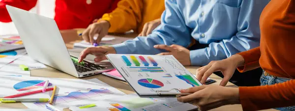 stock image Startup company employee working together, analyzing BI dashboard paper on financial data report and planning strategic marketing for business success in panorama banner. Synergic