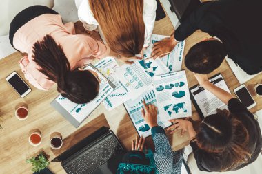 Modern ofisteki iş adamları ve iş kadınlarıyla grup toplantısındaki iş adamlarının en üst düzey görüşü, masada dizüstü bilgisayar, kahve ve belge ile. Kurumsal şirketler uds